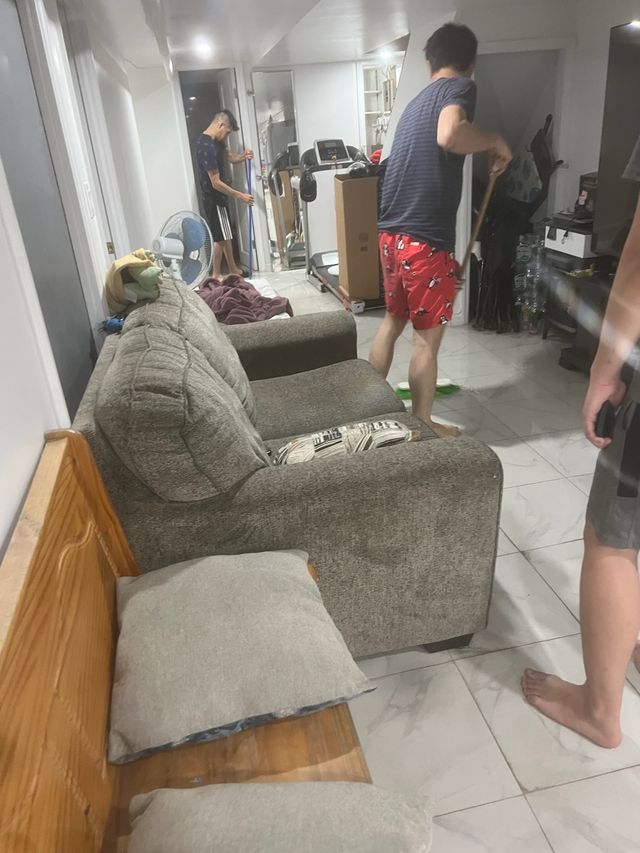 A man vacuums water out of his apartment.